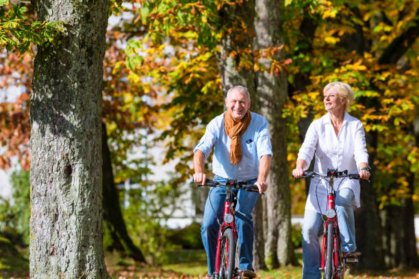 Paar fährt im Herbst mit dem Fahrrad durch den Park